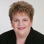 A woman in a black suit is posing for a photo in Seattle.