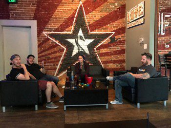 A group of people sitting in a room with a star on the wall, while a WebCami records their meeting.