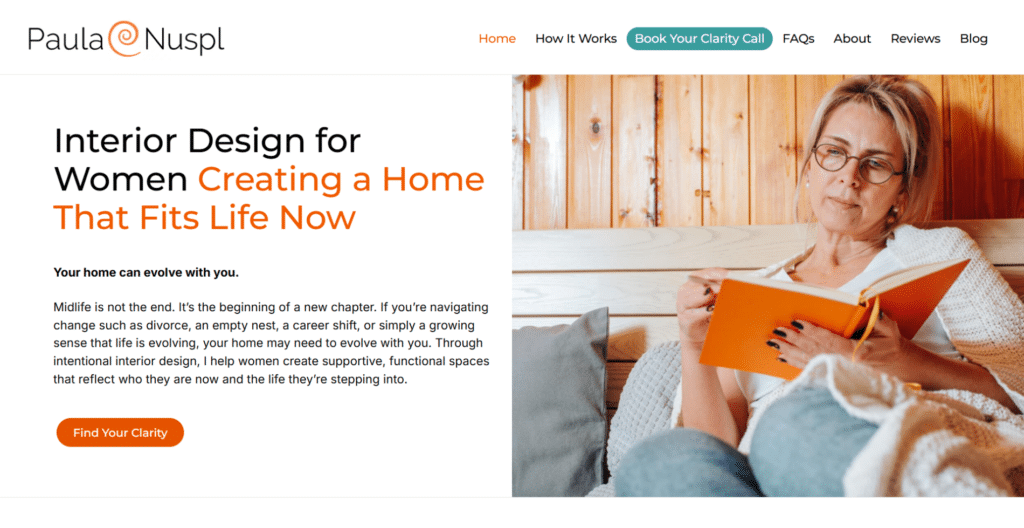 A woman wearing glasses reads and writes in an orange notebook while sitting on a beige couch, featured on an interior design website for women.