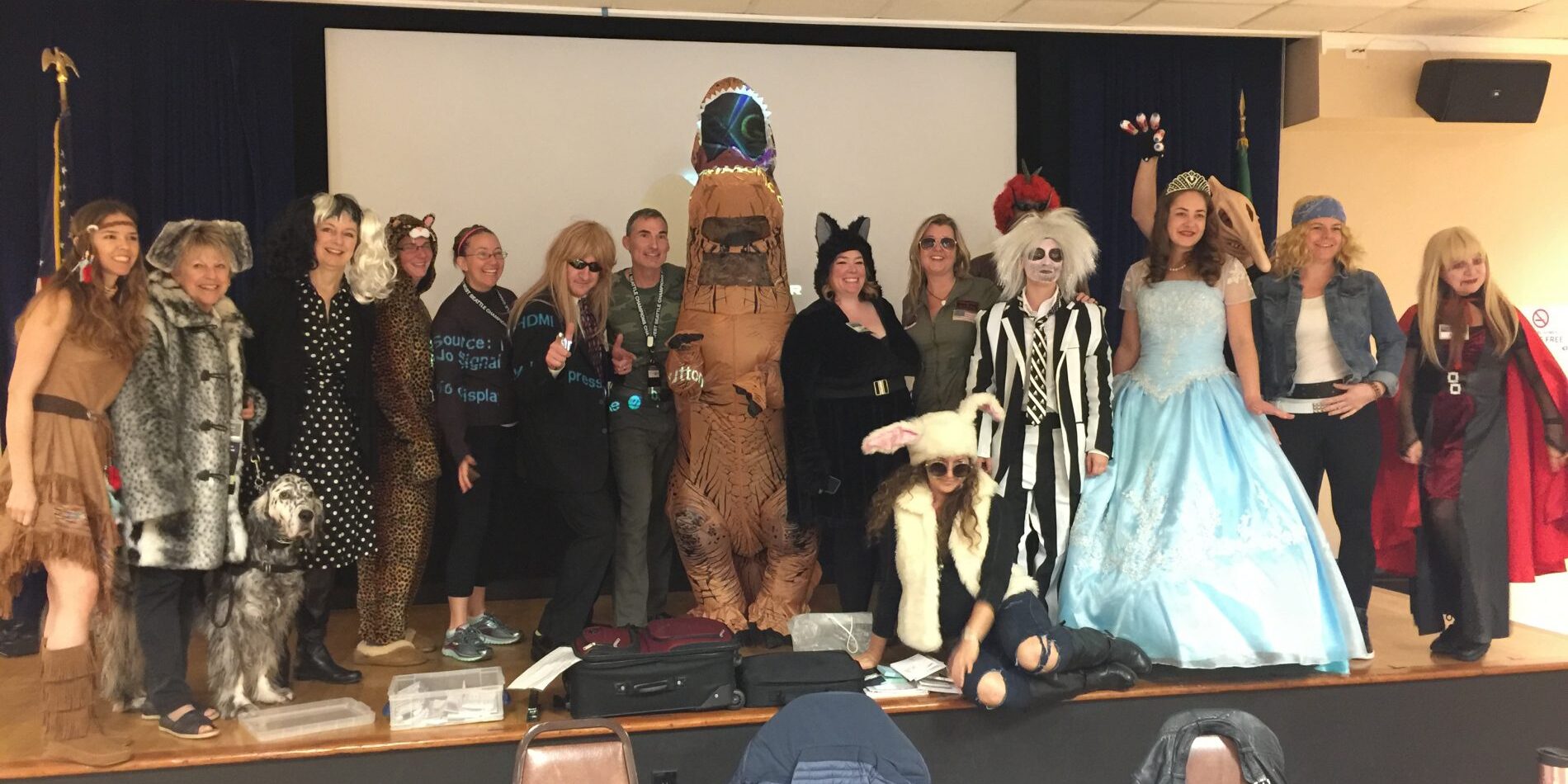 A group of people dressed up in Halloween costumes posing for a picture.