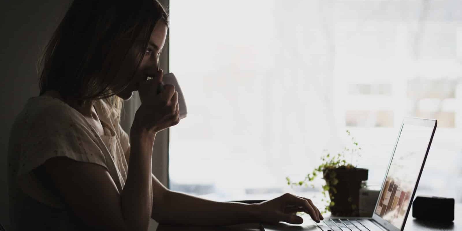 An 18-year-old woman working from home on her laptop.