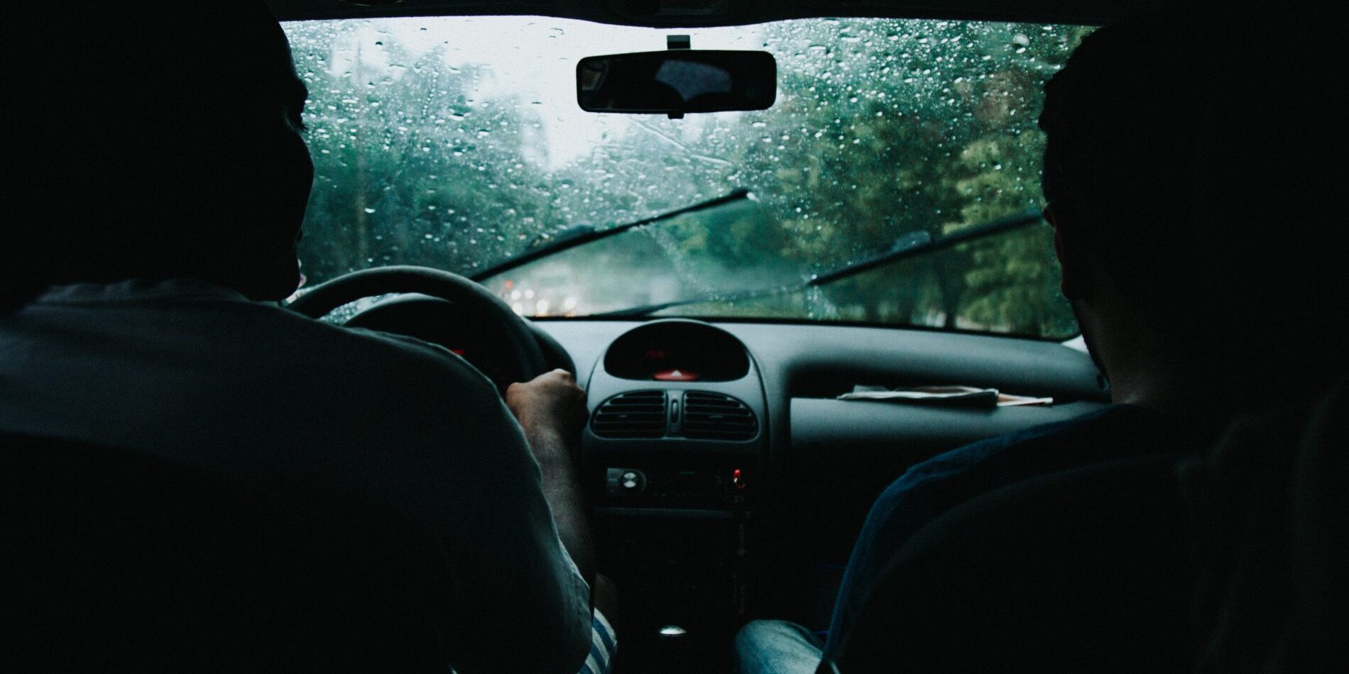 Two people driving a car in the rain while searching for tips on how to clear your browser cache.