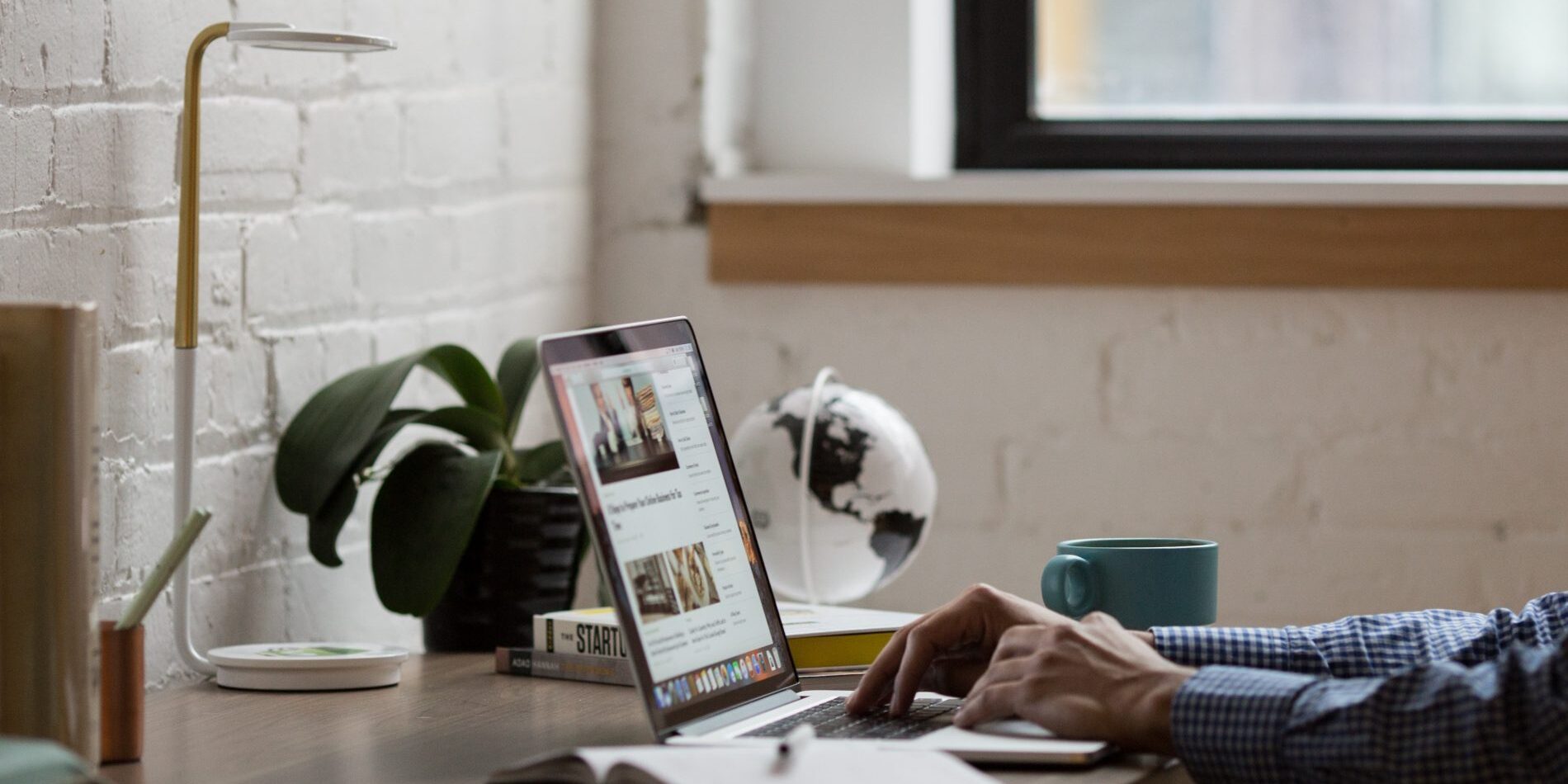 A man diligently working on a laptop at a desk, focusing on the MOST IMPORTANT things to review on your website.