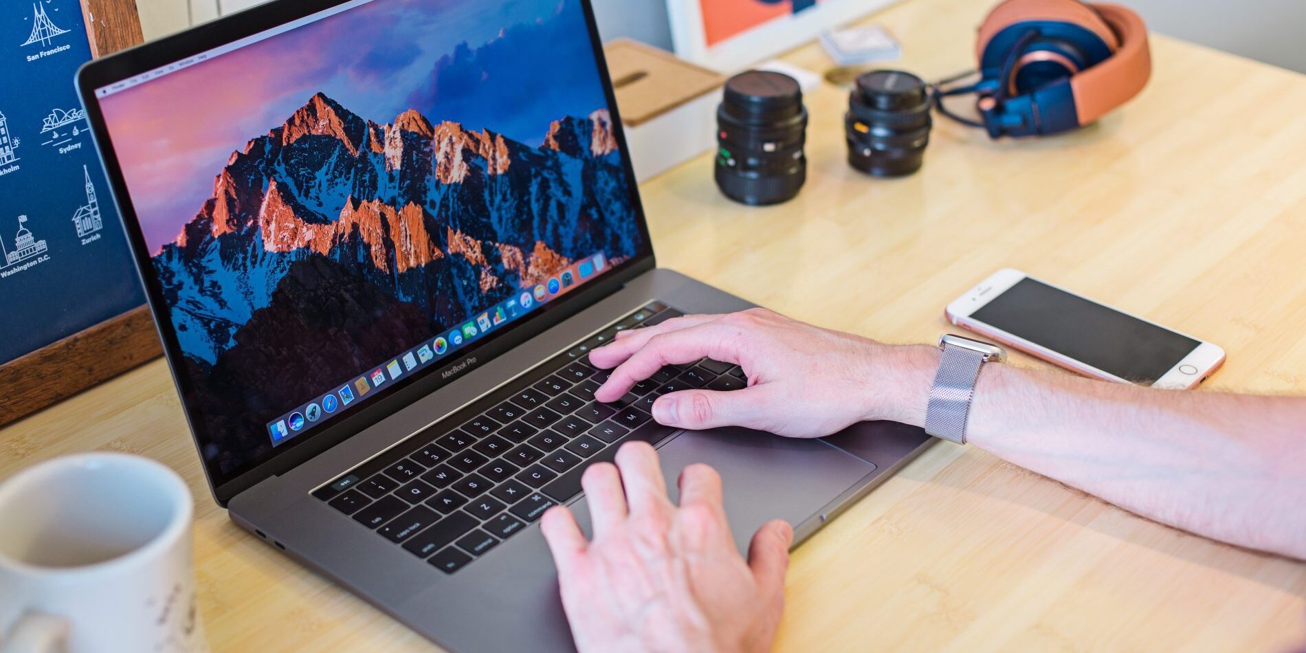 A man using Content Snare to type website content for SEO keywords, with mountains in the background.