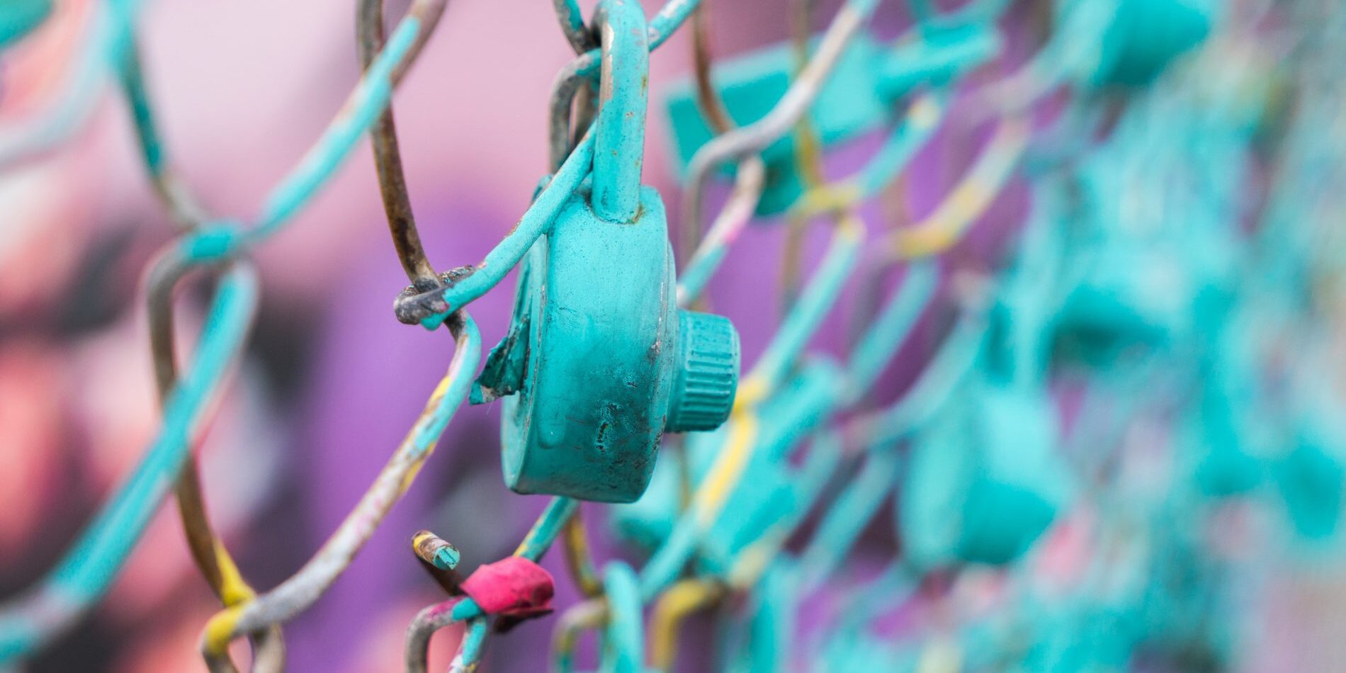 A blue chain link fence adorned with a plethora of colorful locks.