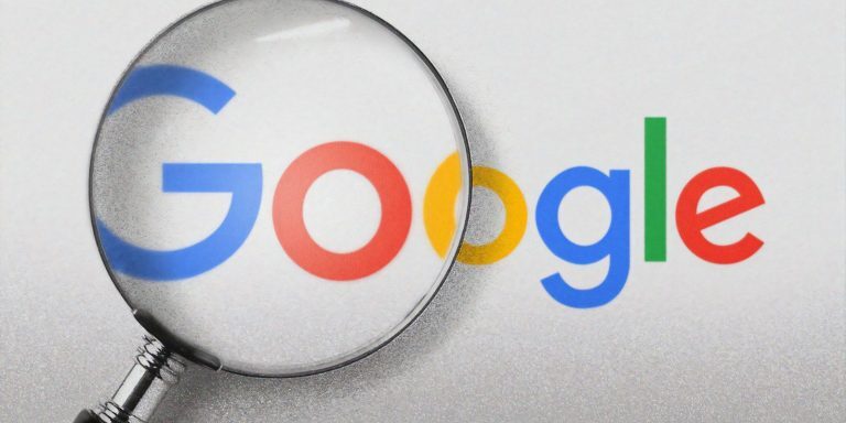 Google logo under a magnifying glass, highlighting the G Suite platform.