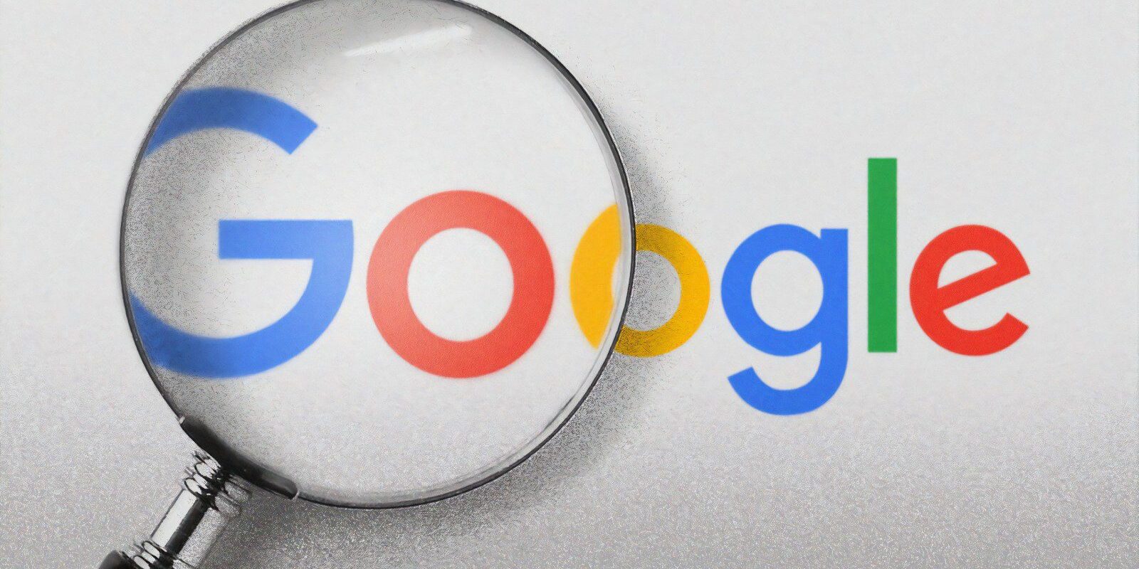 Google logo under a magnifying glass, highlighting the G Suite platform.